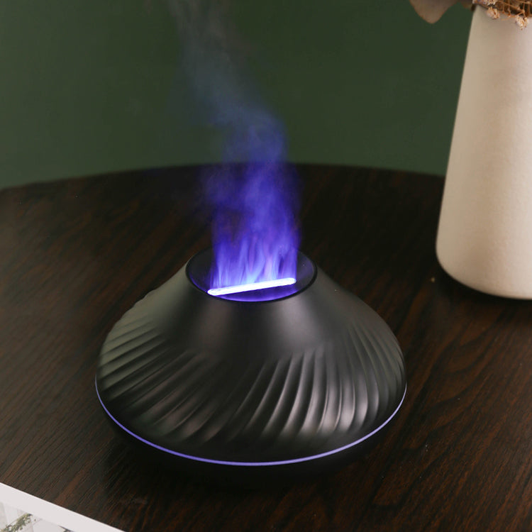 Black LavaLux Aromatherapy Diffuser on a table, turned on, with the LED light set to blue-purple, and mist coming out like a lit but cooling flame.