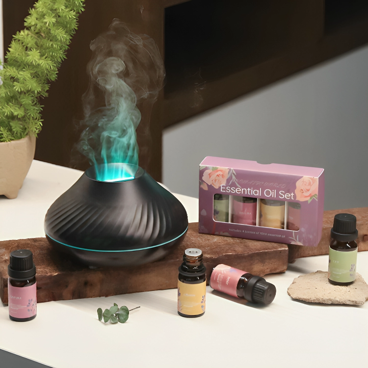 Black LavaLux Aromatherapy Diffuser on a table, turned on, with the LED light set to light blue, and mist coming out like a lit but cooling flame. Next to it are some small bottles of essential oils.