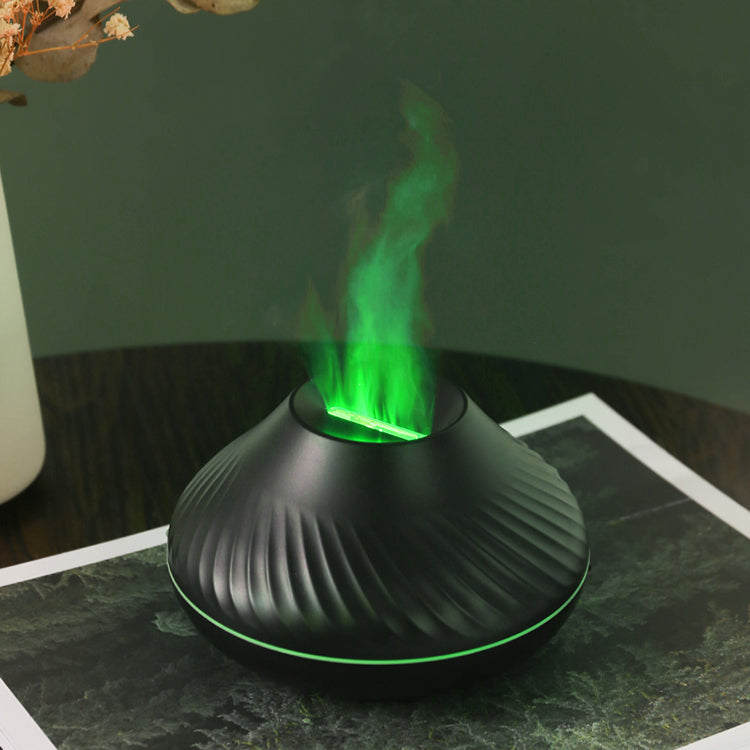 Black LavaLux Aromatherapy Diffuser on a table, turned on, with the LED light set to green, and mist coming out like a lit green flame.